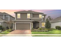 Two-story home with neutral siding, brick paver driveway, and landscaping at 936 Jetway Street, Orange City, FL 32763