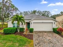 Single-story house with a green door, and a brick driveway at 1037 Balmoral Dr, Davenport, FL 33896