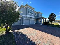 Two-story house with three-car garage and brick driveway at 16750 Toccoa Row, Winter Garden, FL 34787