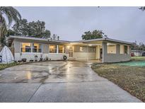 Brick ranch home with carport, mature trees, and a landscaped front yard at 1817 W Grant St, Orlando, FL 32805