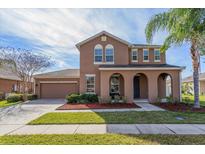 Charming two-story home with well-manicured lawn and arched front porch at 2570 Marshfield Preserve Way, Kissimmee, FL 34746