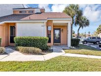 Charming townhouse featuring manicured landscaping, light-colored facade, and stylish front door at 3002 Clubview Dr, Orlando, FL 32822