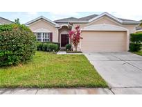 Tan house with a two-car garage and manicured lawn at 337 Fern Lake Dr, Orlando, FL 32825