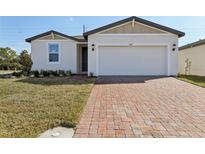 Charming single-story home featuring a brick driveway, manicured lawn, and a two-car garage at 4537 Sidesaddle Trl, St Cloud, FL 34772