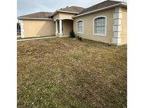 Tan house with white garage door and columns at 975 Gascony Ct, Kissimmee, FL 34759