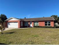 Brick house with a two-car garage and a well-maintained lawn at 102 San Blas Ave, Kissimmee, FL 34743