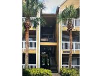 Exterior view of condo building with stairs and palm trees at 1071 S Hiawassee Rd # 1213, Orlando, FL 32835