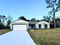 Newly constructed one-story home with a white garage door and gray exterior at 1211 Baltic Dr Dr, Poinciana, FL 34759