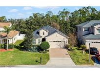 Single-Gathering home with two-car garage, manicured lawn, and brick driveway at 15925 St Clair St, Clermont, FL 34714