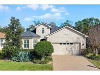 Two-story house with a beige exterior, gray roof, and a two-car garage at 15925 St Clair St, Clermont, FL 34714