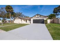 Updated home exterior featuring a large driveway and manicured lawn at 2247 King Edwards Ct, Winter Park, FL 32792