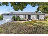 Ranch style home with gray exterior, landscaped lawn, and attached garage at 2823 Cady Way, Winter Park, FL 32792