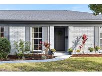 Charming home featuring a gray brick exterior, a welcoming front door, and professional landscaping at 2823 Cady Way, Winter Park, FL 32792