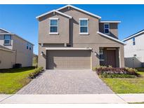 Two-story house with a large garage and a brick driveway at 2949 Muller Oak Loop, Ocoee, FL 34761