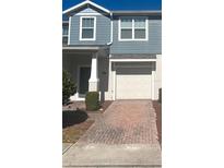 Two-story townhome with gray siding, white trim, and a brick paver driveway at 4126 Hedge Maple Pl, Winter Springs, FL 32708