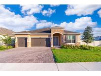 New 3-car garage home with paver driveway and landscaped lawn at 4767 Cragmere Loop, Clermont, FL 34711