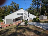 Unique gray two-story home with creative vertical column design and inviting driveway and landscaping at 800 Lake Marion Dr, Altamonte Springs, FL 32701