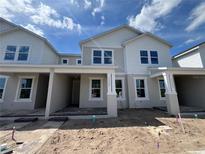 Charming new construction two-story home with stone accents, covered entry and well-lit windows at 13556 Autumn Harvest Ave, Winter Garden, FL 34787