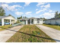 One-story home with a green exterior, driveway, and basketball hoop at 1424 Sheridan Sw St, Winter Haven, FL 33880