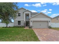 Charming two-story home featuring an attached two-car garage and a well-manicured front lawn at 1700 Underwood Ave, St Cloud, FL 34771