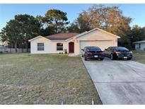 House exterior showcasing a two-car garage and well-maintained lawn at 3054 Shallowford St, Deltona, FL 32738