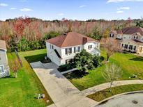 Two-story house with a red roof and large backyard in a residential neighborhood at 413 Country Cottage Ln, Winter Garden, FL 34787
