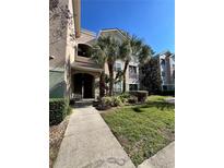 Exterior of two-story condo building with palm trees and walkway at 4865 Cypress Woods Dr # 2109, Orlando, FL 32811