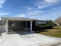 Single-story home with carport and landscaped yard at 711 Dolphin Dr, Tavares, FL 32778