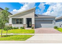 One-story home with gray siding, stone accents, and a two-car garage at 1146 Boardwalk Pl, Kissimmee, FL 34747