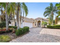 Charming home with lush landscaping, brick driveway, and a tile roof provides curb appeal at 12161 Obelia Ln, Orlando, FL 32827