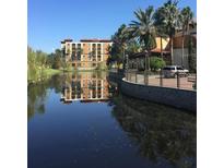 Resort-style community with lake view and palm trees at 12539 Floridays Resort Dr # 210D, Orlando, FL 32821
