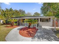 Charming mid-century home with a covered entryway and lush landscaping at 145 Verbena Dr, Orlando, FL 32807