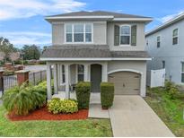 Two-story house with gray siding, landscaping, and a two-car garage at 206 Aberdeen Street St, Davenport, FL 33896