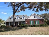 Charming brick home with dormer windows, green shutters, and a well-maintained front yard at 34122 Park Ln, Leesburg, FL 34788