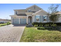 Charming two-story home boasts a two-car garage, well-maintained lawn and beautiful landscaping at 4485 Lions Gate Ave, Clermont, FL 34711