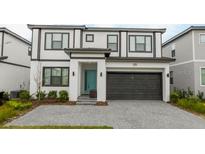 Two-story home with gray roof, white exterior, and teal door at 6152 High Seas Dr, Orlando, FL 32821