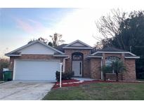 Brick house with a two-car garage and landscaped front yard at 113 W 1St St, Debary, FL 32713
