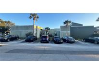 Exterior view of a condo building with parking lot and tropical landscaping at 198 Scottsdale Sq # 198, Winter Park, FL 32792