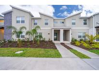 New construction townhome featuring modern design, stone accents, and professionally landscaped front yard at 2974 Protagonist St, Kissimmee, FL 34746