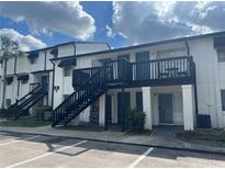 Two story building showcasing stairways, front doors, and exterior patios under a partly cloudy sky at 4111 S Semoran Blvd # 11, Orlando, FL 32822