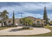 Beautiful two-story home with circular driveway and landscaped yard at 8702 Bristol Park Dr, Orlando, FL 32836