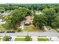 Aerial view of a house under construction, surrounded by lush trees and other homes at 1705 Geigel Ave, Orlando, FL 32806