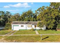 White single-story house with attached garage, driveway, and landscaped lawn at 208 S Main Ave, Minneola, FL 34715