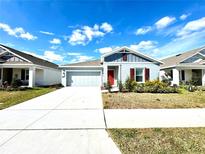 Curb appeal abounds in this charming new home with a red door and attached garage at 245 Lawson Ave, Haines City, FL 33844