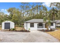 Newly renovated home with a storage shed and landscaped yard at 25753 Vero St, Sorrento, FL 32776