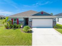 Curb appeal abounds in this charming one-story home, featuring a stone facade and red shutters at 3842 Whitetail Ct, St Cloud, FL 34772