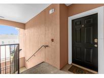 Inviting entryway with a modern black door and neutral-colored walls at 6413 Astor Village Ave # 313, Orlando, FL 32835