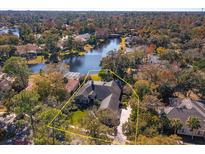 Aerial view of a secluded home surrounded by mature trees and a serene lake at 812 Edgeforest Ter, Sanford, FL 32771