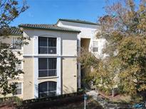 Tan three-story building with green accents and balconies at 8908 Legacy Ct # 201, Kissimmee, FL 34747