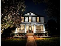 Two-story house with a brick pathway, lush landscaping, and nighttime illumination at 11413 Camden Park Dr, Windermere, FL 34786